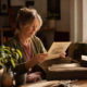 A mature woman rediscovering an unfinished artwork in a sunlit studio
